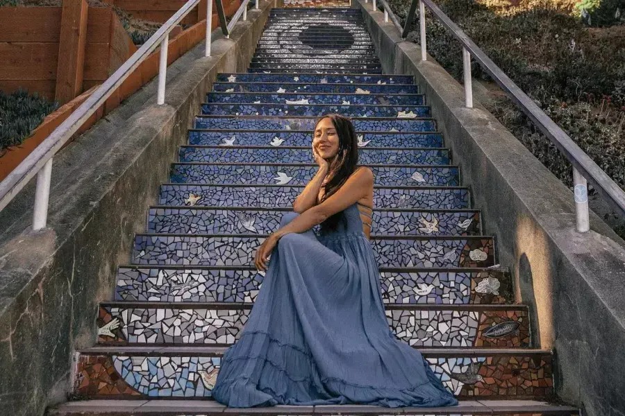 Uma mulher posa sentada nas escadas de azulejos da 16th Avenue, no bairro Sunset, em São Francisco.