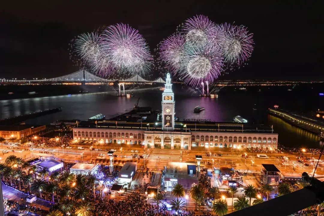 Fireworks explode over top of the Ferry Building, with the Bay Bridge in the background. 圣弗朗西斯科，加州.