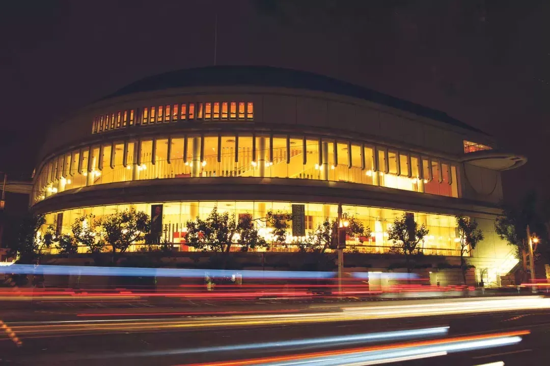 路易丝的外场. Davies Symphony Hall di notte con strisce di luce provenienti dai veicoli in transito.