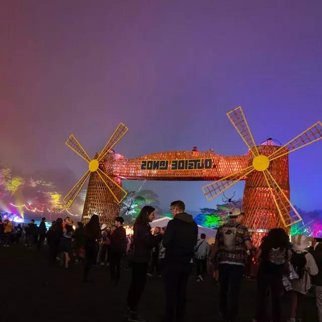 サンフランシスコのアウトサイド・ランズ音楽フェスティバルで、ネオンライトに囲まれた夜のフェスティバル参加者の群れが写っている。