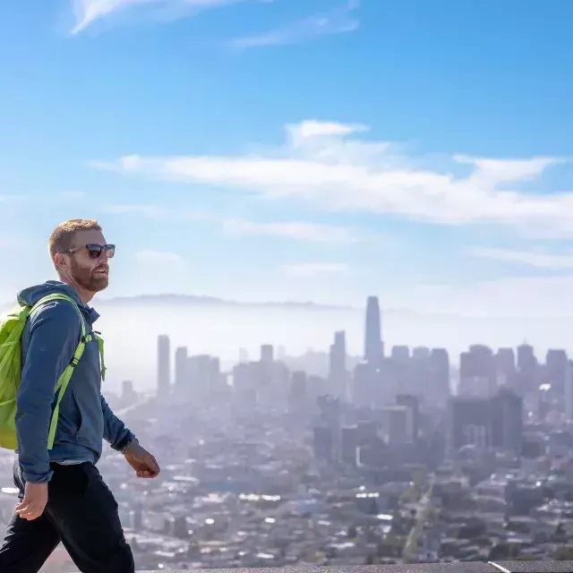 A visitor hikes to the top of Twin Peaks with his backpack.