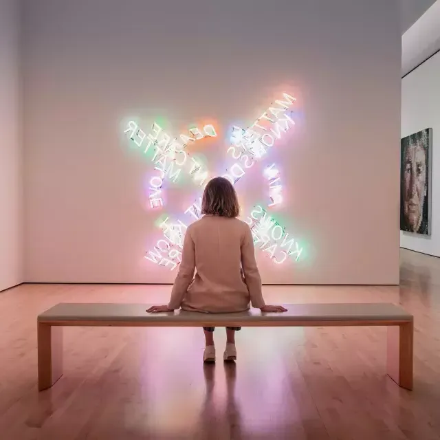 一个女人, sentada em um banco, observa uma obra de arte contemporânea de luz no SF MOMA, em São Francisco.