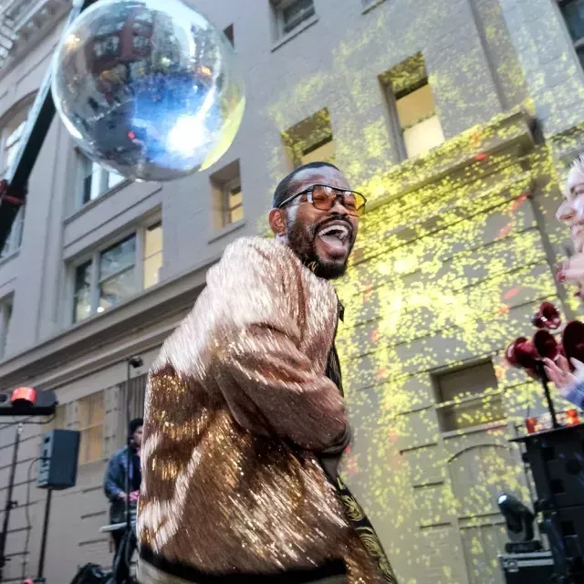 Dançarina dançando sob uma bola de discoteca gigante em São Francisco